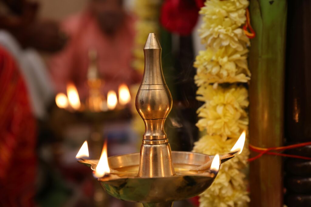 Close-up of a brass diya with yellow flowers during a festive occasion in India.