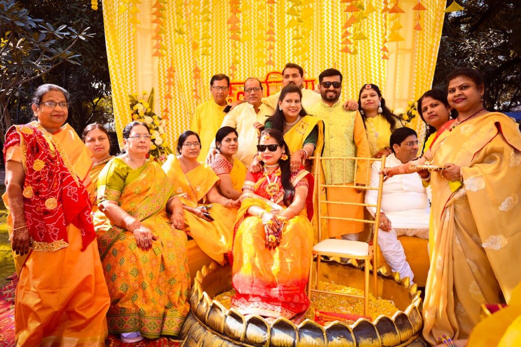 Family gathers for joyful Haldi ceremony during a vibrant Indian wedding celebration.