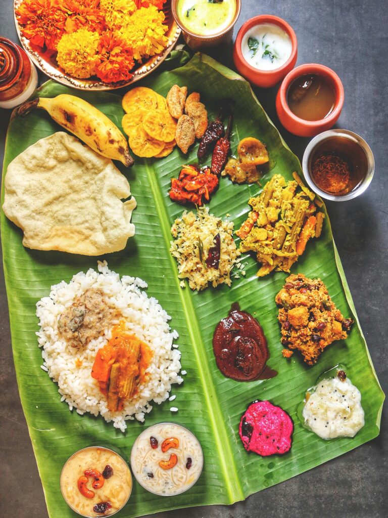 A vibrant display of Kerala Sadya on banana leaf, featuring traditional Onam dishes.