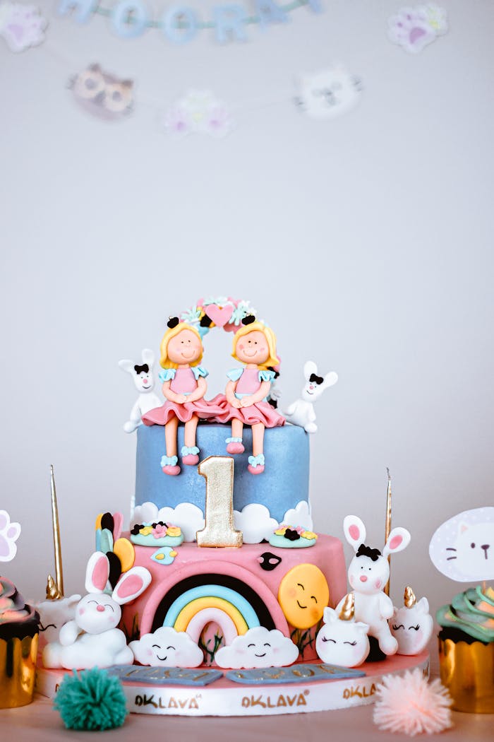 Home A vibrant cake adorned with fondant figures, perfect for a first birthday celebration.
